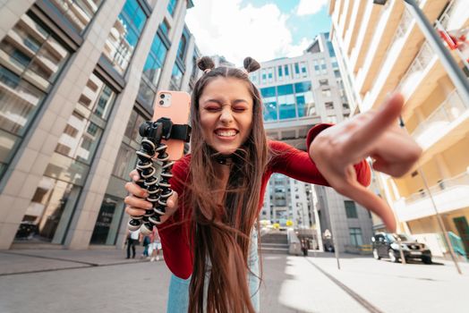 Young female blogger streaming on the street. Close view