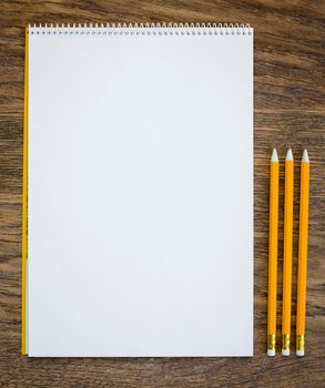 Paper and pencils on the wooden table. close-up.