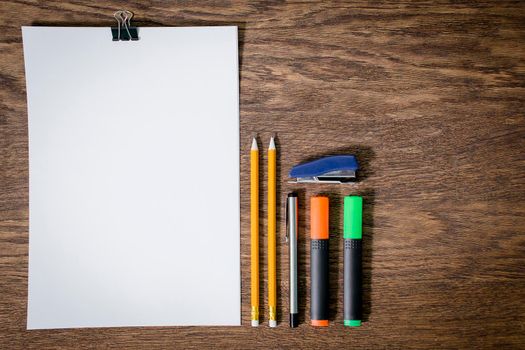 Paper and pencils on the wooden table. close-up.