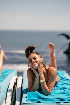 A young beautiful woman in swimsuit sunbathes on a sun lounger by the pool at the hotel.Summer concept.