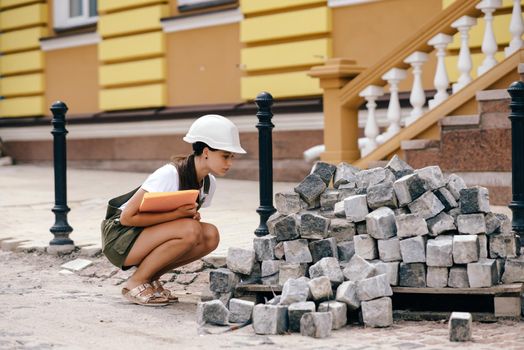 A woman civil engineer counts building materials at a construction site. Construction engineer woman concept