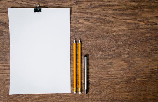 Paper and pencils on the wooden table. close-up.