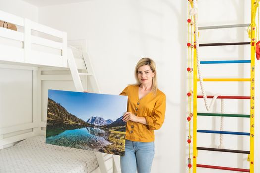 Woman hanging a photo canvas on a wall