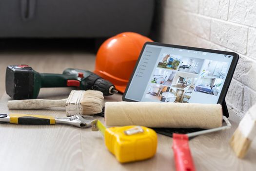 repair, diy and home improvement concept - close up of tablet pc computer and painting tools on table