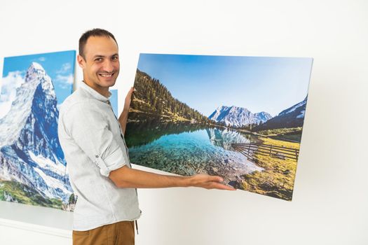 Modern Home Interior And Domestic Decor. a man is holding a photo canvas.