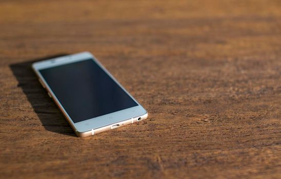 White phone on a wooden table. close-up