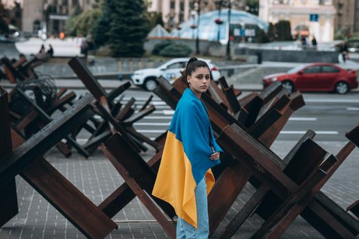 Young woman with national flag of Ukraine walking in the city