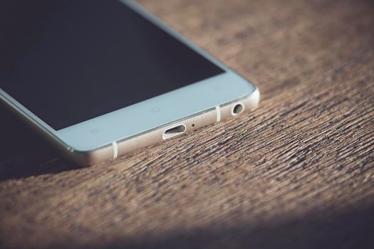 White phone on a wooden table. close-up