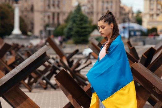 Young woman with national flag of Ukraine walking in the city