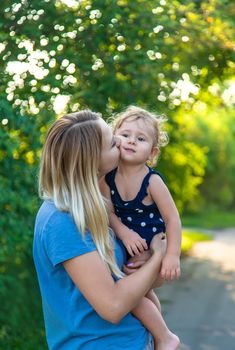 Mother in the park with a child in her arms. Selective focus. Kid.