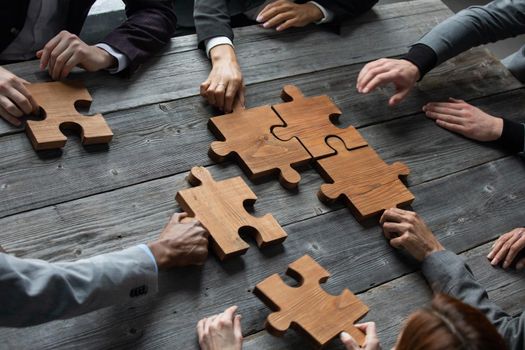 Business people team work with wooden puzzle cooperation unity concept