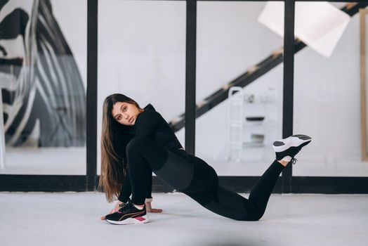 Side view of flexible girl exercising yoga pose indoors. Concept of yoga.