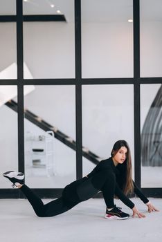 Side view of flexible girl exercising yoga pose indoors. Concept of yoga.