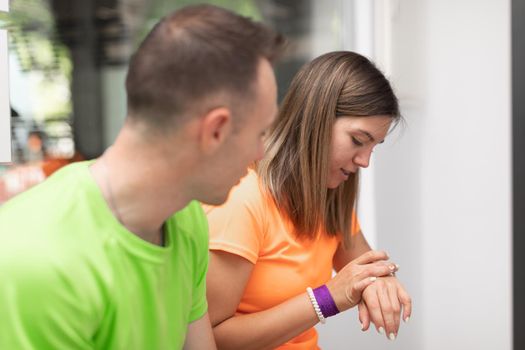 A female trainee looking at her watch during a break at the crossfit box