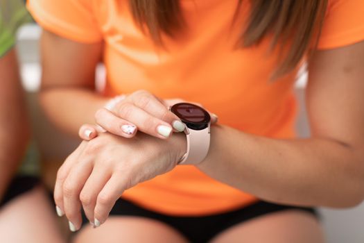 Close-up of a female trainee looking at her watch during a break at the crossfit box