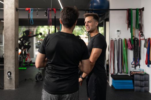 Two personal trainers talking to each other during a break at the crossfit box