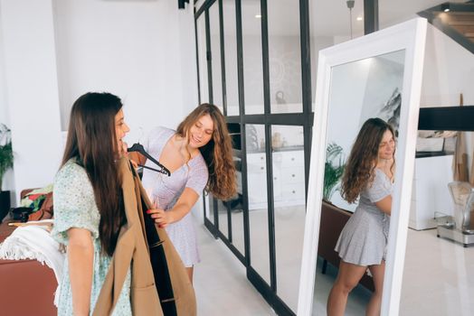 Image of pretty females trying on dress at home