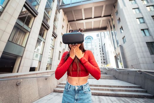 A woman in a virtual reality helmet walks down the street