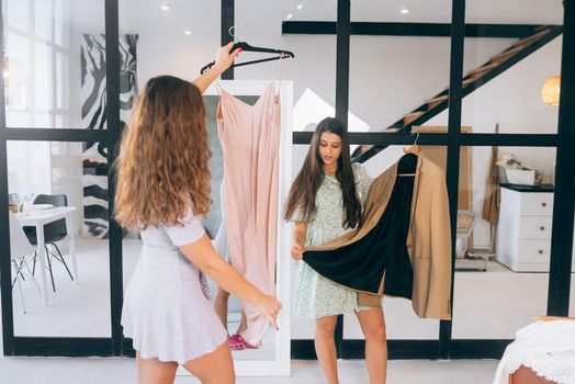 Image of pretty females trying on dress at home