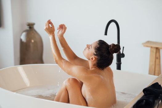 Pretty young woman taking bath at home