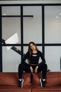 Pretty athletic girl sitting on sofa back