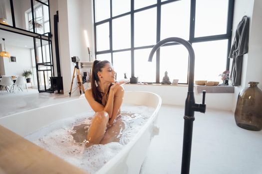Pretty young woman taking bath at home