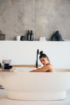 Pretty young woman taking bath at home