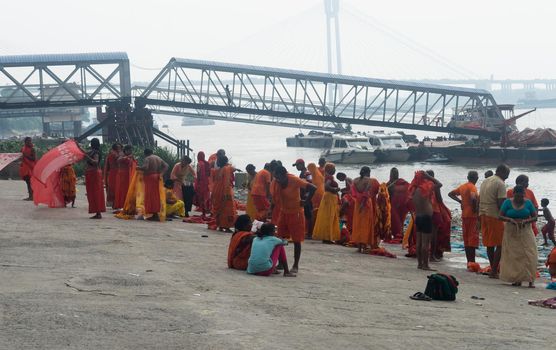 Pilgrim People are taking bath at the riverbank of the Ganges or river Hooghly . Babu Ghat, Kolkata, West Bengal, India. August 2, 2022