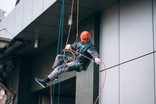 Industrial climber in uniform and helmet rises. Outdoor