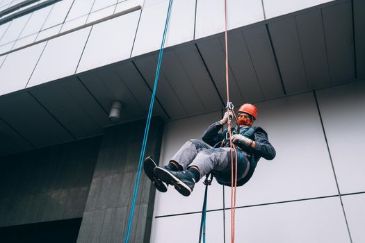 Industrial climber in uniform and helmet rises. Outdoor