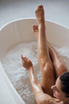 Pretty young woman taking bath at home