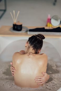 Pretty young woman taking bath at home