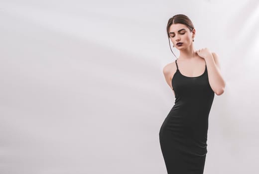 Portrait of nice young gorgeous woman on gray solid backgrounds. To a lots of copy space.
