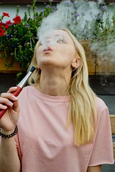 Young woman smokes a hookah in a restaurant. Portrait.