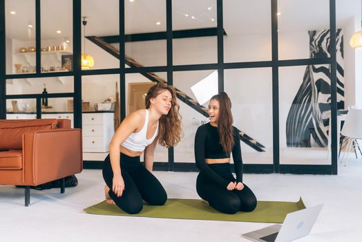 Two girls practice yoga at home