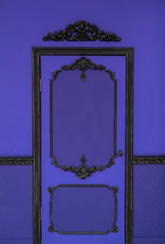 Old dramatic violet doors on the background of the wall.