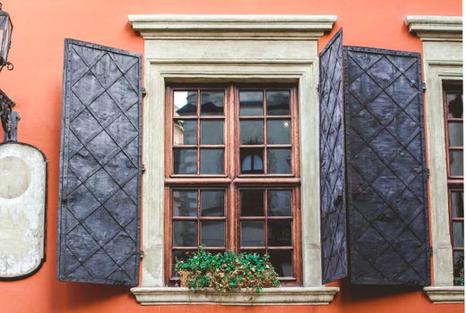 Old windows on the background of an orange wall in the old courtyard of the city.