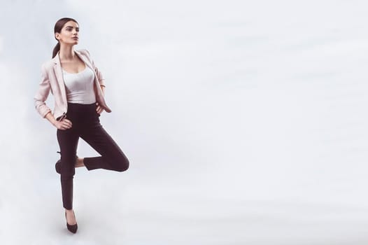 Portrait of nice young gorgeous woman on gray solid backgrounds. To a lots of copy space.