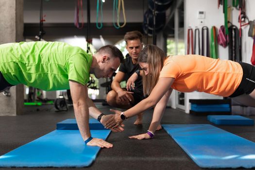 A couple of trainees giving high-fives while laying on the floor as an exercise at the crossfit box