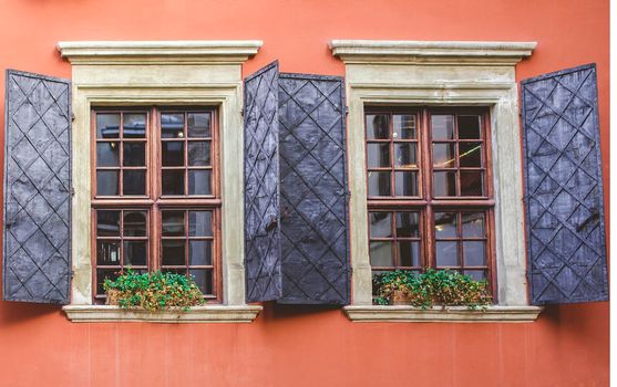 Old windows on the background of an orange wall in the old courtyard of the city.