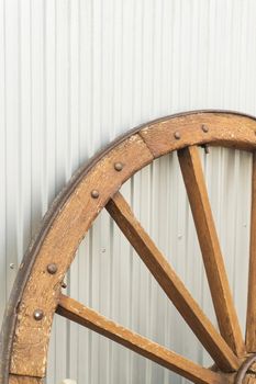 Antique wooden wheel on metallic background close up