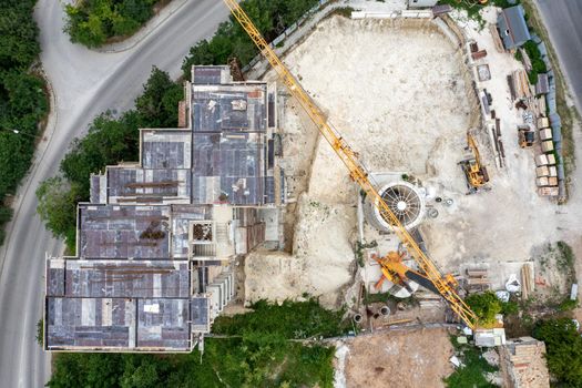 Working at the construction site, building a new house. Aerial top view from drone