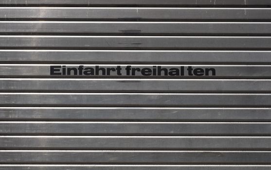 German metal garage door with text Einfahrt freihalten translation Keep entrance free