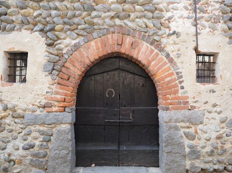 ancient medieval wooden door gate in stone and brick wall