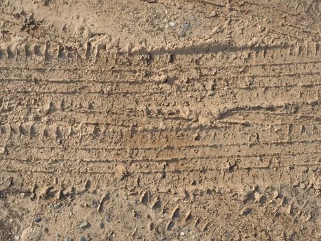 tyre footprint in brown earth soil useful as a background