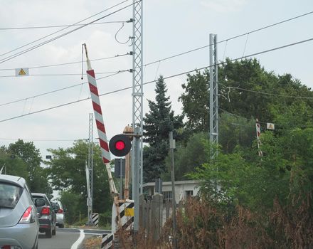cars at rail level crossing with red signal and barrier