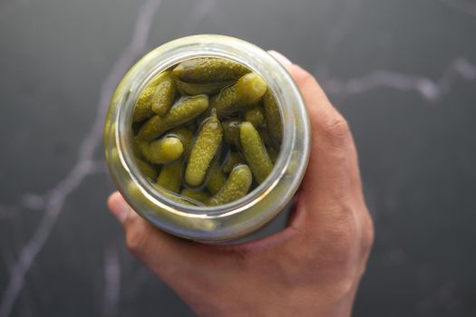 bottle of pickled cucumbers, pickles on table .
