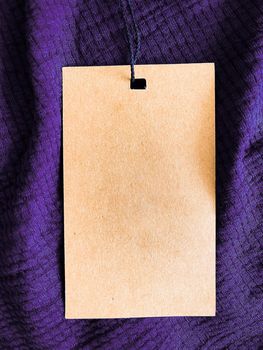 Blank fashion label tag, sale price card on luxury fabric background, shopping and retail concept