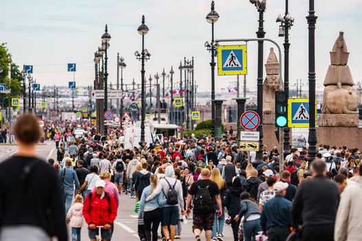 Russia, St. Petersburg, 31 July 2022: A lot of people during celebration of day of Navy on university embankment, lampposts . High quality photo
