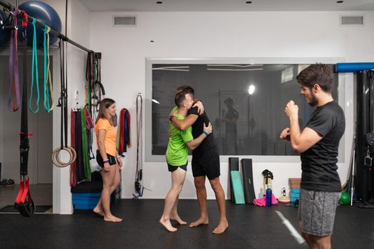 Trainee and trainer giving each other a hug during a break at the crossfit box